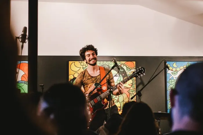 Ravi Brasileiro com guitarra em apresentação intimista